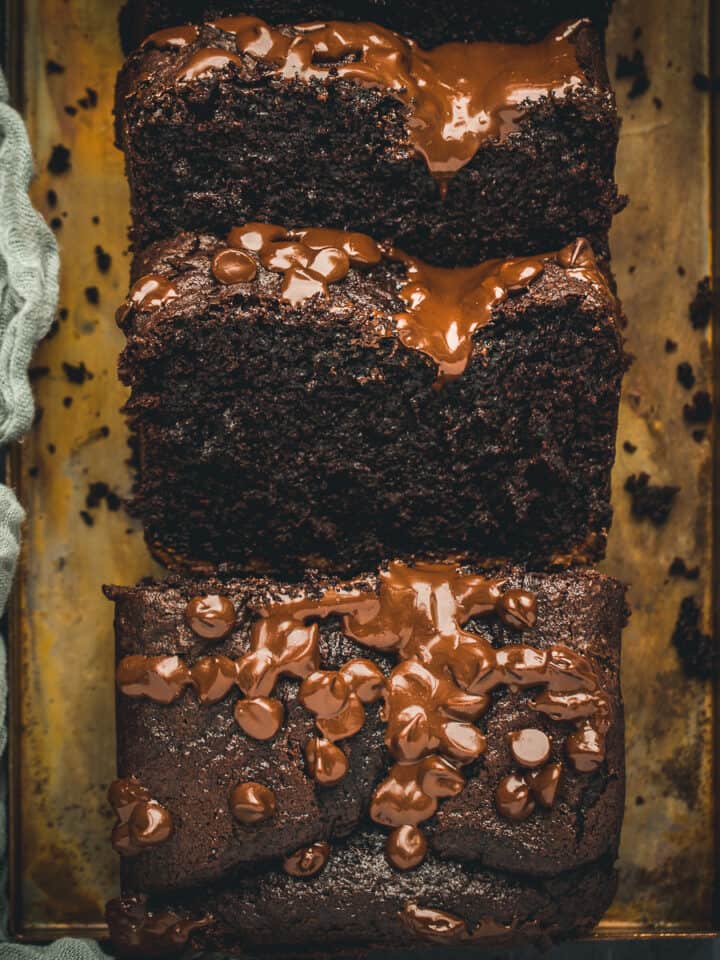 A chocolate loaf cake that has had slices cut away.