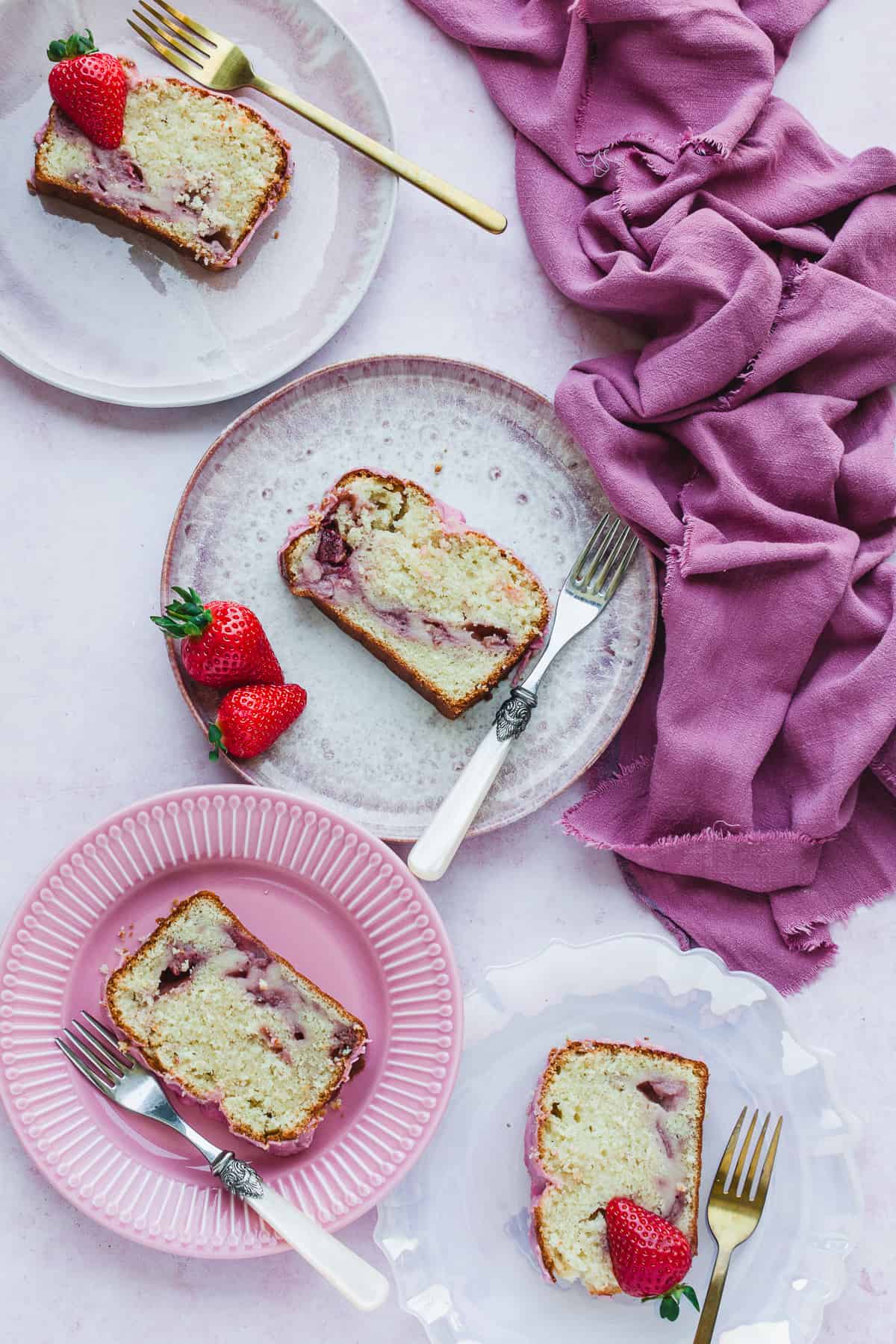 Slices of freshly baked Strawberry Pound cake on pink plates. 