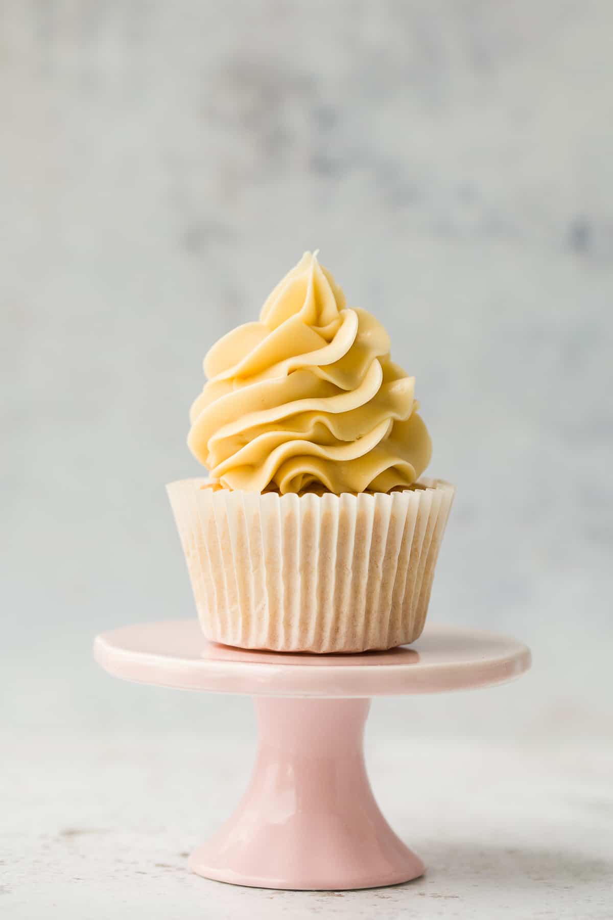 A perfect vanilla cupcake with a swirl of frosting on top. 