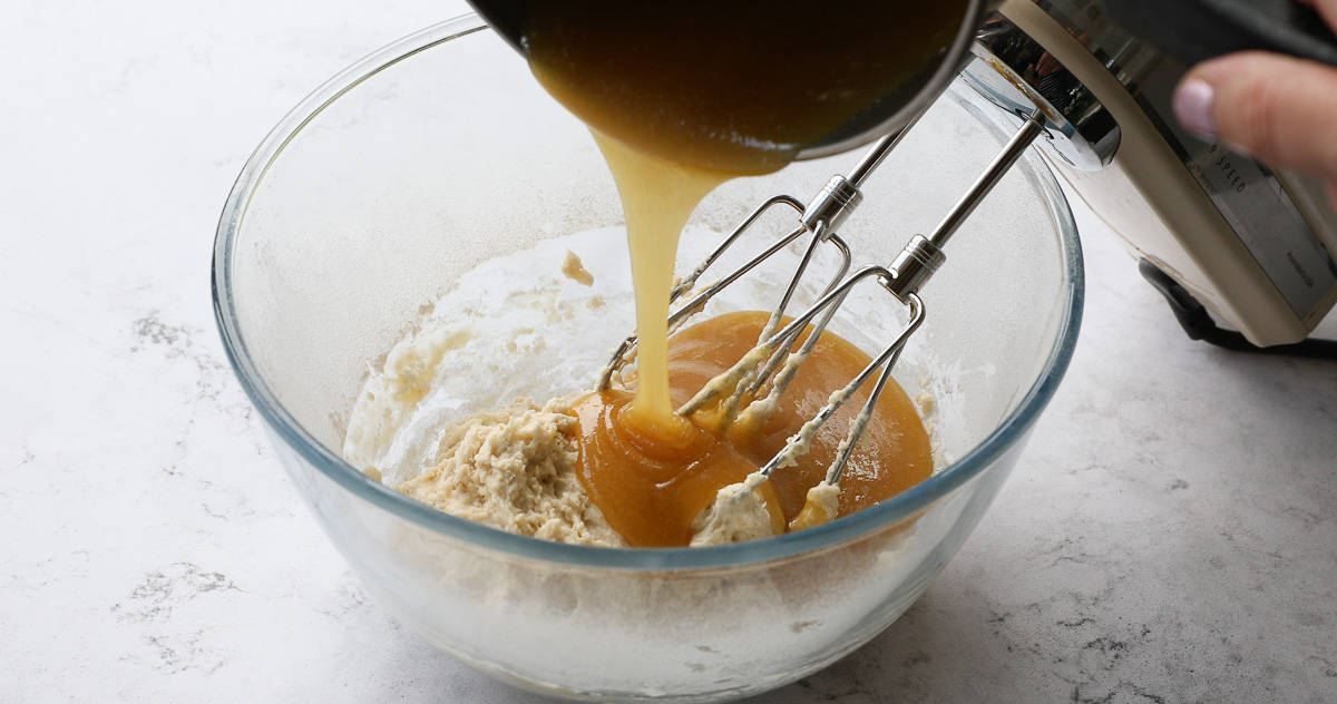 Pouring golden syrup mixture into a glass mixing bowl. 