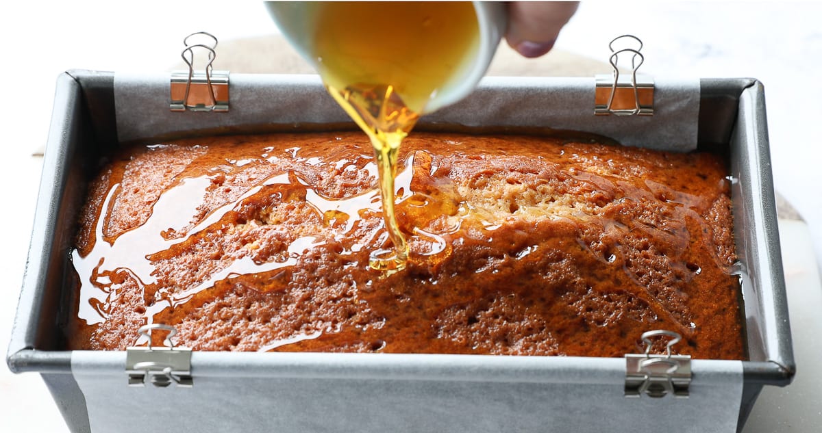 Drizzling golden syrup on top of a baked cake. 