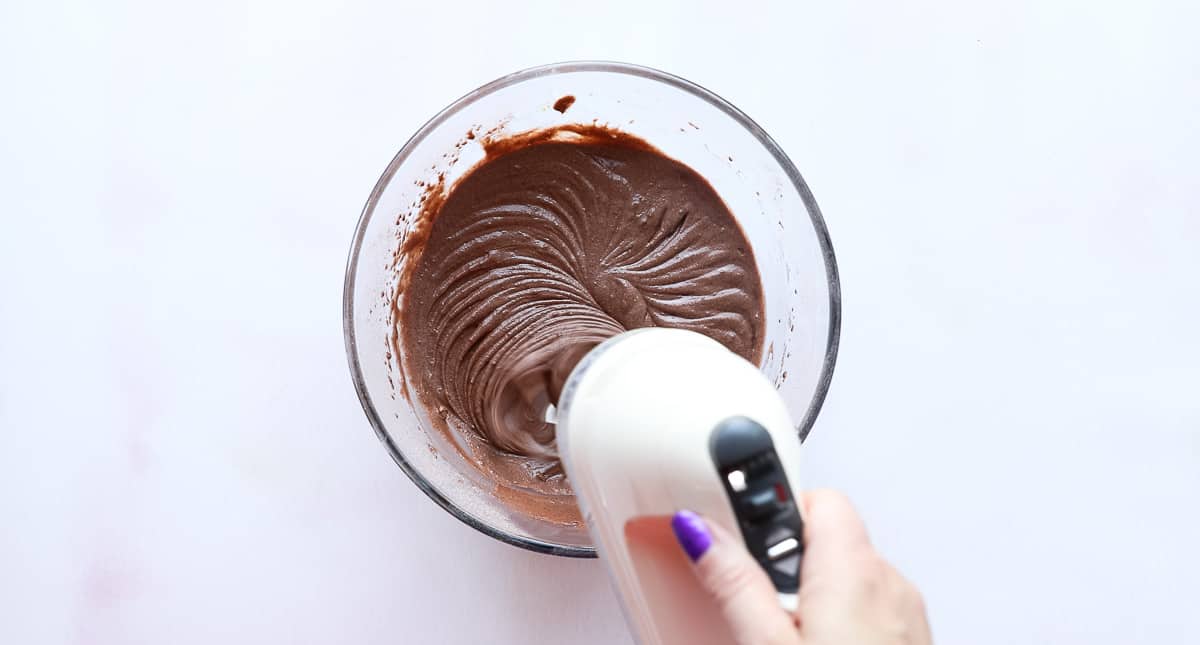 A mixing bowl containing a chocolate cupcake batter. 